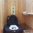 Toilettehäuschen WIESE aus Lärchenholz – mit Biolan eco – Innenansicht mit optionalen Kindersitz und Einstreukiste
