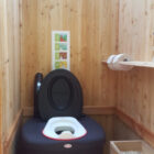 Toilettehäuschen WIESE aus Lärchenholz – mit Biolan eco – Innenansicht mit optionalen Kindersitz und Einstreukiste