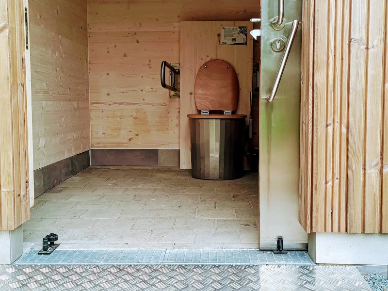 Detailansicht der barrierefreien Trockentoilette KUBUS mit Schiebetür und barrierefreiem Zugang