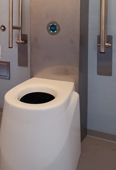 ECODOMEO Trockentoilette – Aktivierung des Förderbands per Knopfdruck (elektrisch betrieben)