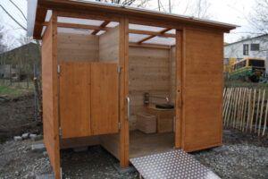 Komposttoilette WALD-barrierefrei mit getrenntem Urinalraum - Frontansicht, Detail barrierefreie Toilette Innenraum