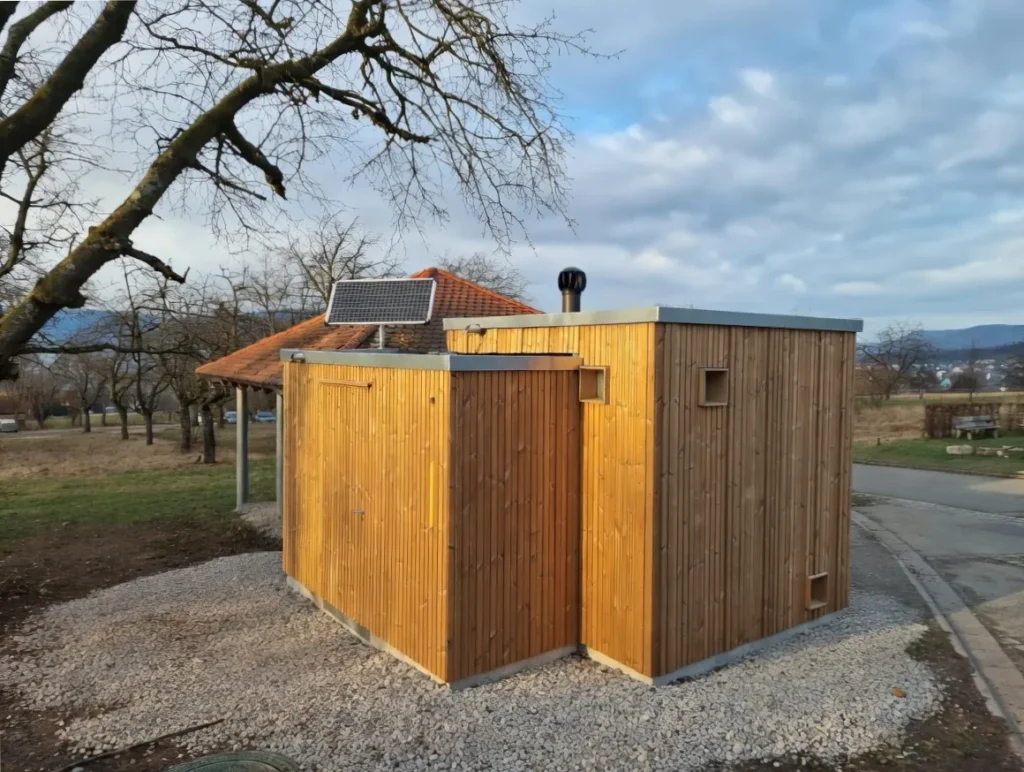 Kubus Toiletten-Kubus von hinten mit Zugangstür zum Technikraum und Solarpanel